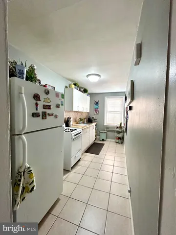 a kitchen with a refrigerator a stove top oven and a sink