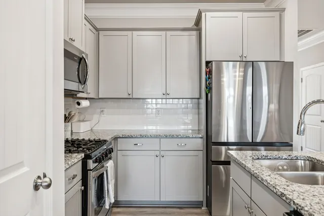a kitchen with stainless steel appliances granite countertop a sink stove and refrigerator