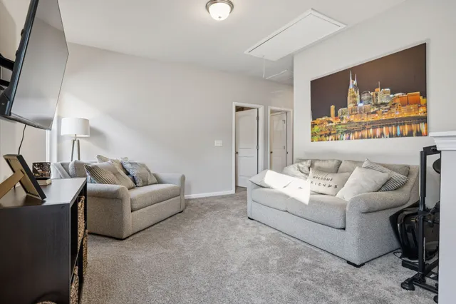 a living room with furniture a flat screen tv and a window