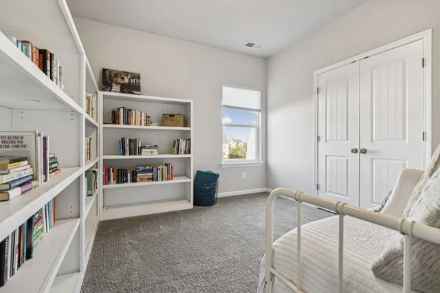 a living room with furniture and a book shelf