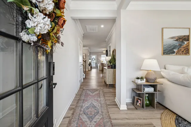 a view of a hallway with wooden floor and a potted plant