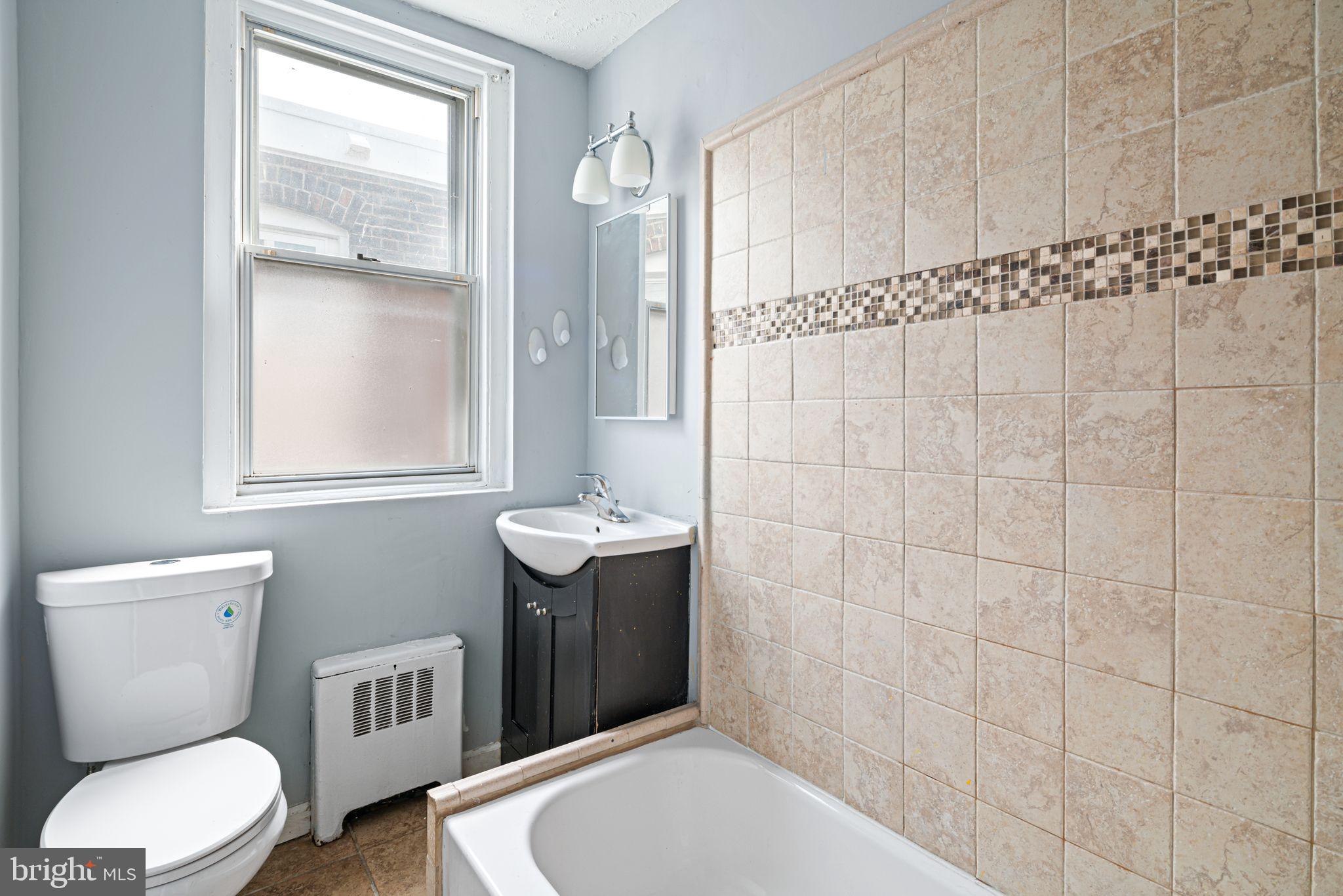 4606 Benner Street Philadelphia, PA 19135 - Photo 11 of 13 a bathroom with a sink a toilet and shower