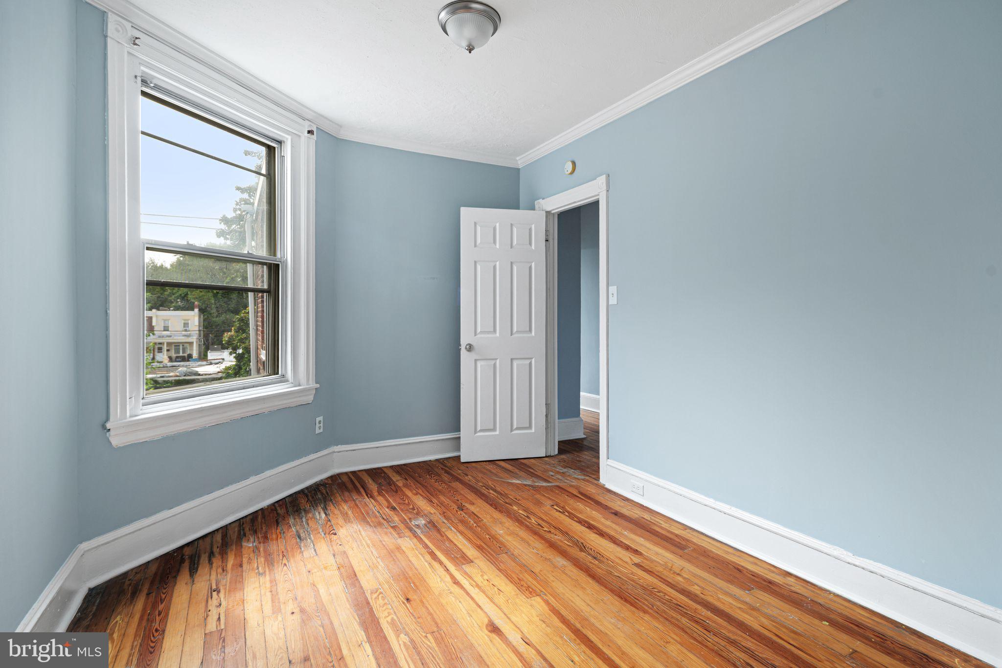 4606 Benner Street Philadelphia, PA 19135 - Photo 8 of 13 an empty room with wooden floor and windows