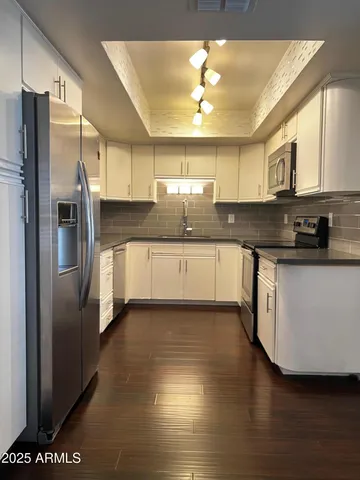 a kitchen with stainless steel appliances granite countertop a sink a stove and refrigerator