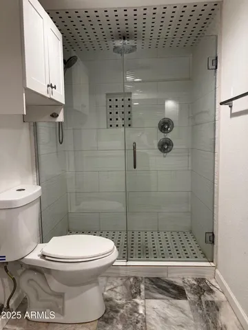 a bathroom with a toilet and shower