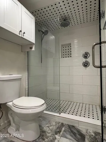 a bathroom with a toilet and a shower