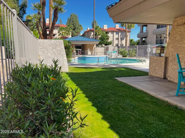 a view of a white house with a big yard and potted plants