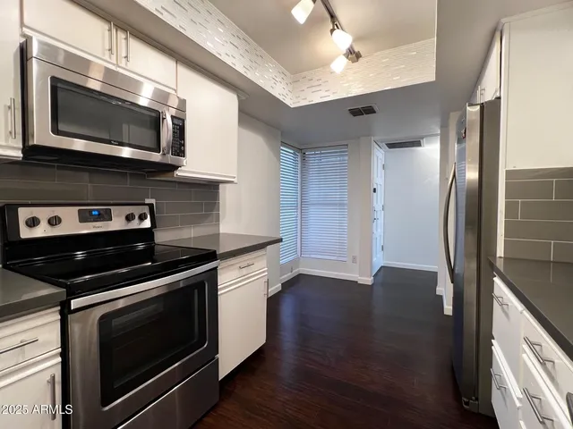 a kitchen with stainless steel appliances a stove microwave and sink