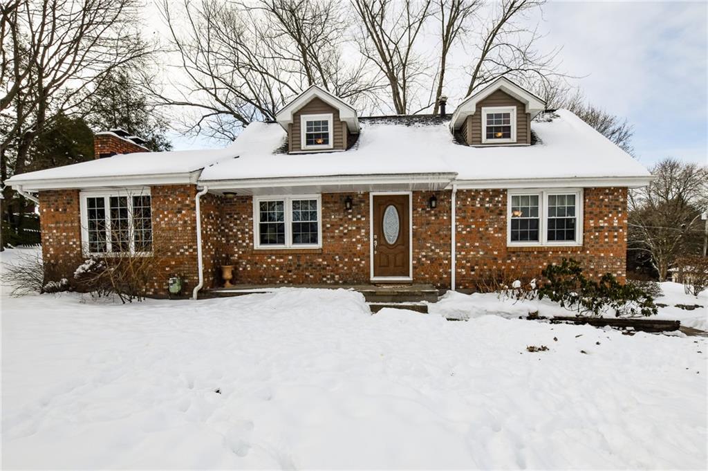 front view of a house with a yard covered in snow
