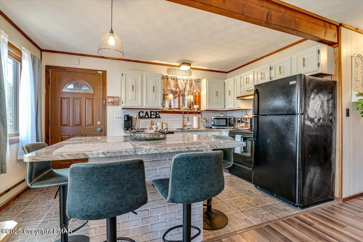 1037 Porter Drive Bushkill, PA 18324 - Photo 12 of 45 a kitchen with stainless steel appliances granite countertop a refrigerator a sink a stove a dining table and chairs with wooden floor