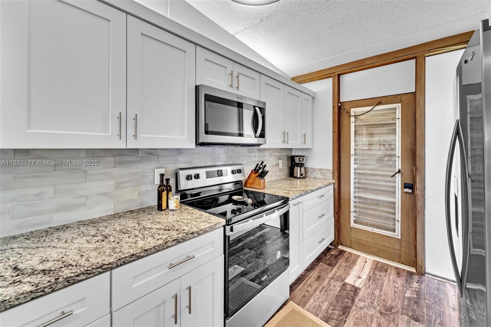 1456 Northeast Ocean Boulevard, Unit 7204 Stuart, FL 34996 - Photo 25 of 64 a kitchen with stainless steel appliances granite countertop a stove a sink and a refrigerator