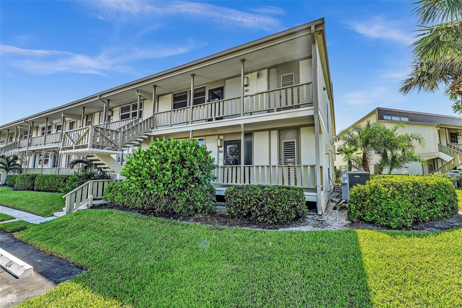 1456 Northeast Ocean Boulevard, Unit 7204 Stuart, FL 34996 - Photo 38 of 64 a large building with a big yard and potted plants in front of it