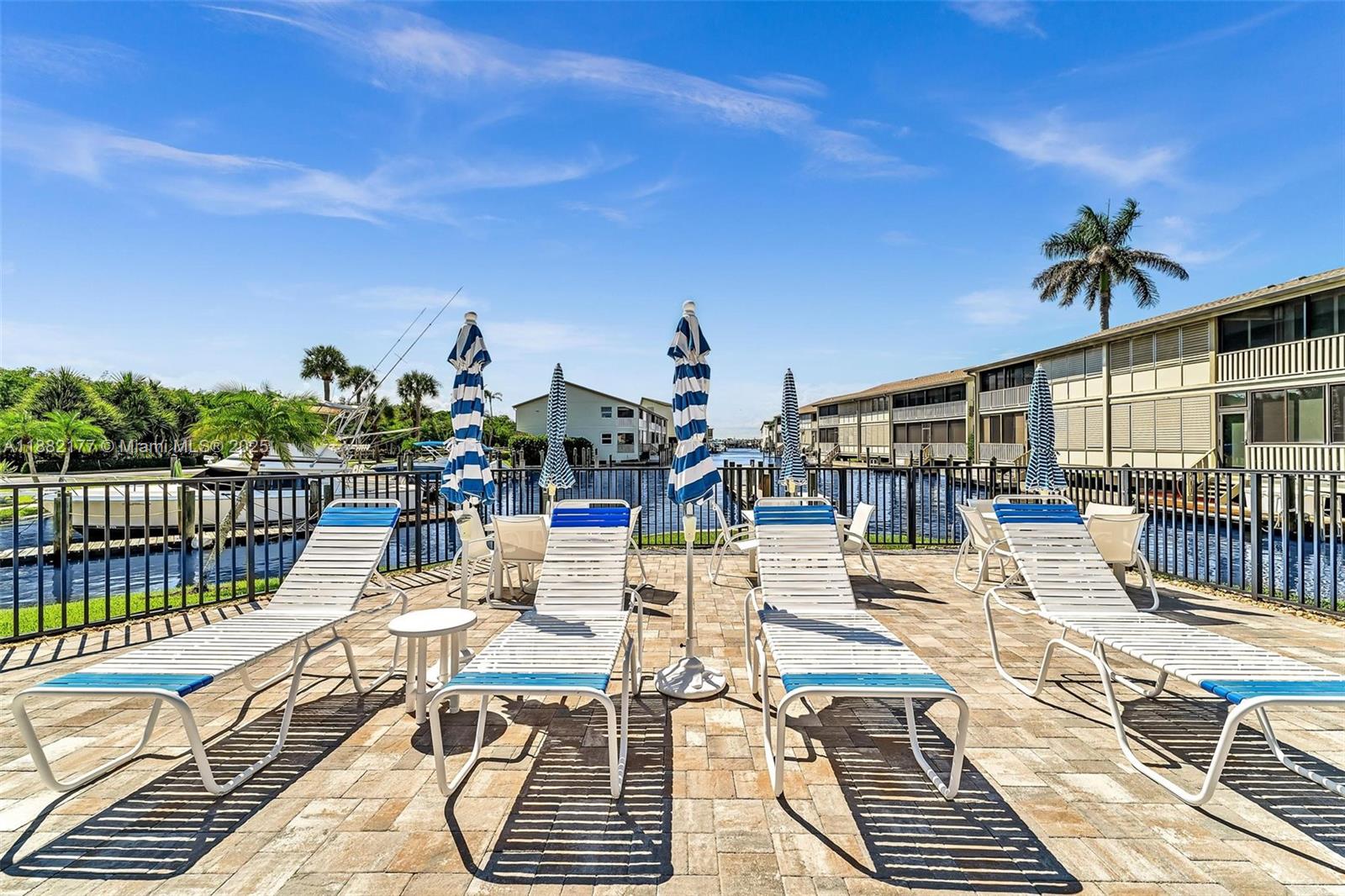 1456 Northeast Ocean Boulevard, Unit 7204 Stuart, FL 34996 - Photo 42 of 64 a view of a balcony with dining table and chairs