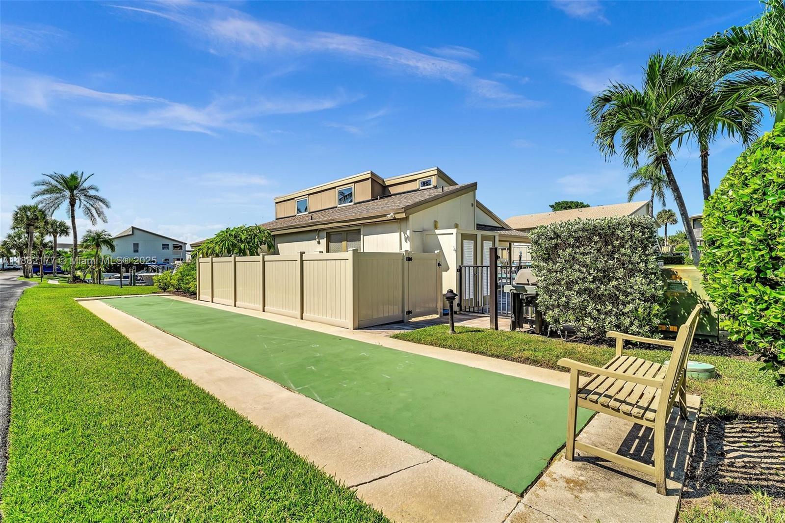 1456 Northeast Ocean Boulevard, Unit 7204 Stuart, FL 34996 - Photo 47 of 64 a front view of a house with a yard and garage