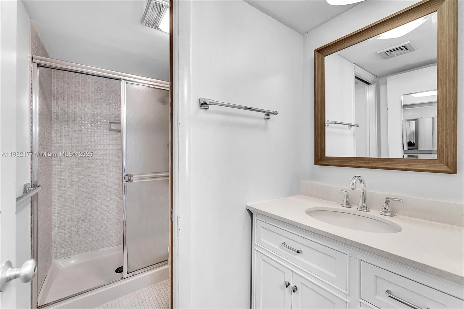 1456 Northeast Ocean Boulevard, Unit 7204 Stuart, FL 34996 - Photo 5 of 64 a bathroom with a shower sink and mirror
