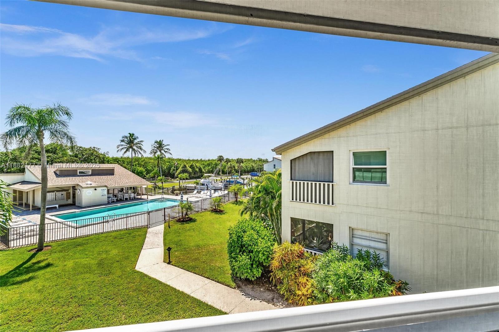 1456 Northeast Ocean Boulevard, Unit 7204 Stuart, FL 34996 - Photo 9 of 64 a view of a swimming pool with an outdoor seating and a yard