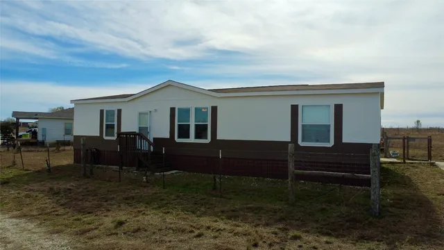 a view of house with yard and sitting area