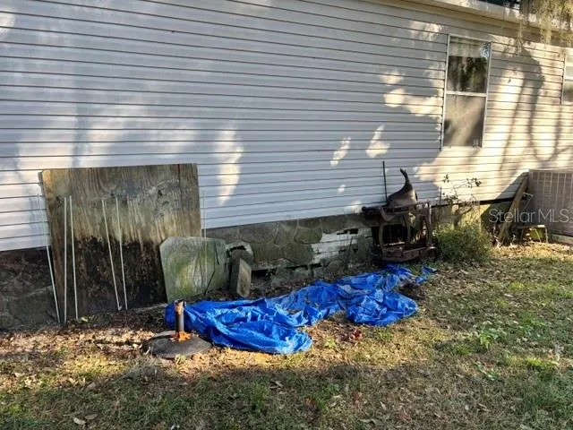 a view of a backyard with chairs and potted plants