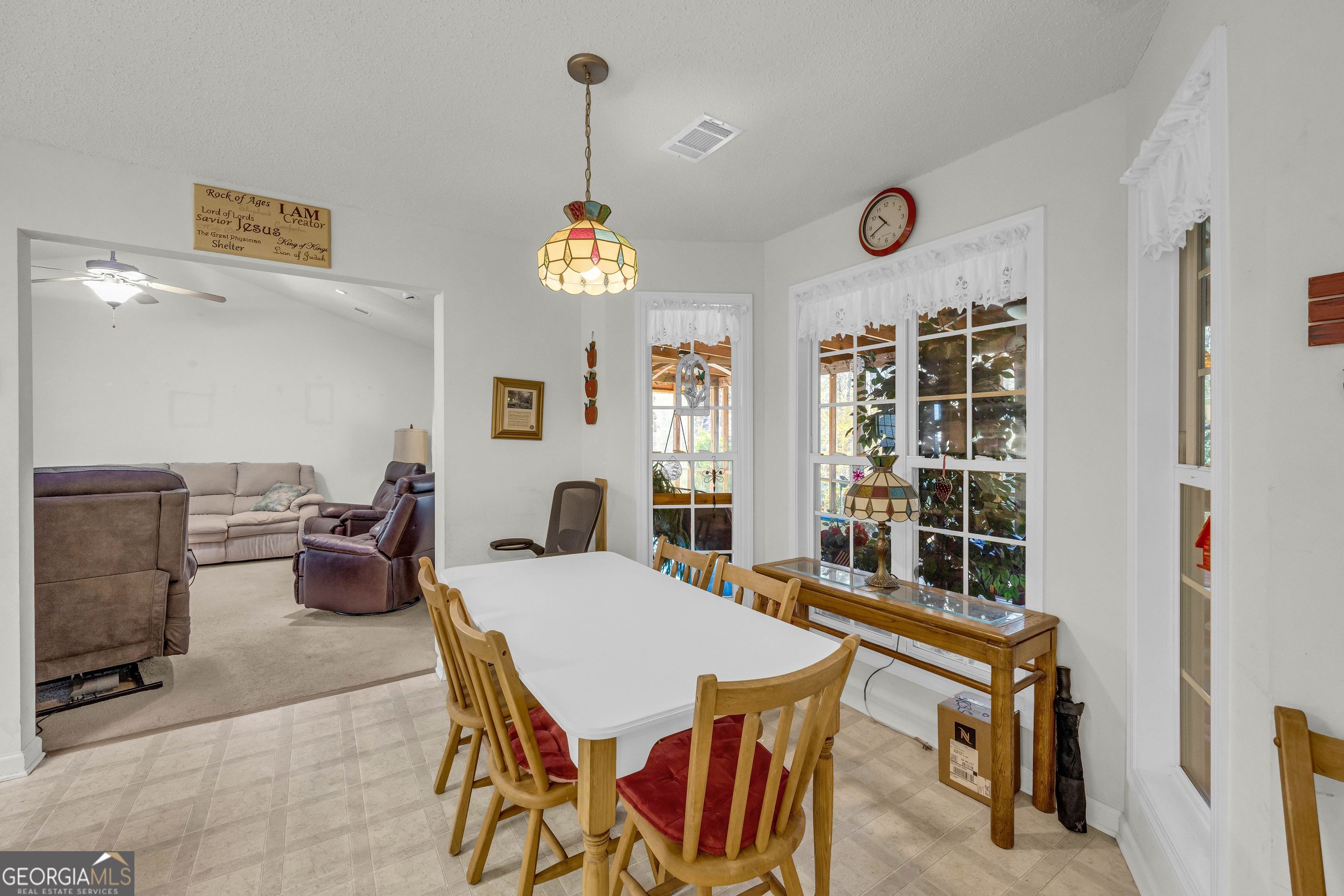 357 Sundew Lane Mount Airy, GA 30563 - Photo 21 of 53 a view of a dining room and livingroom with furniture wooden floor a rug and a clock