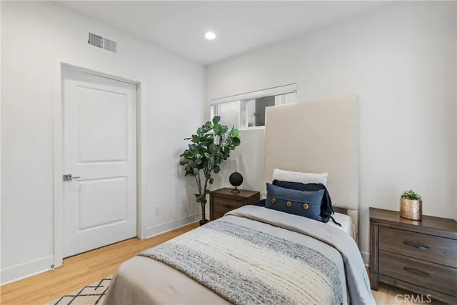 a bedroom with a bed and a potted plant