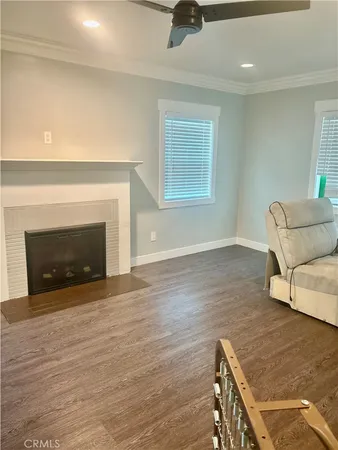 a view of an empty room with wooden floor and a fireplace