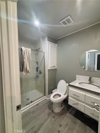 a bathroom with a granite countertop sink toilet and shower