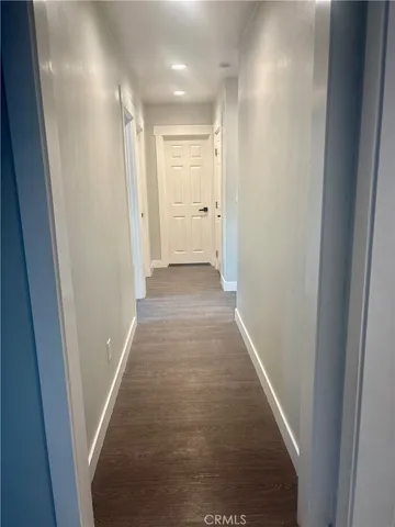 a view of a hallway with wooden floor and a hallway