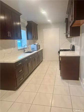 a kitchen with stainless steel appliances a sink a stove a refrigerator and cabinets