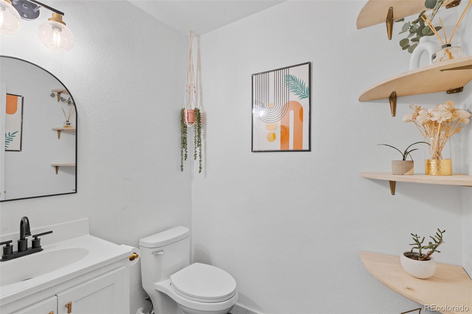 8674 Carr Loop Arvada, CO 80005 - Photo 15 of 43 a bathroom with a toilet a sink and mirror