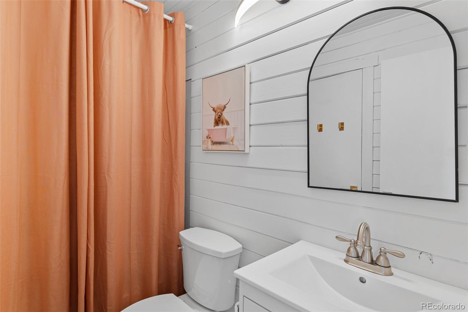 8674 Carr Loop Arvada, CO 80005 - Photo 20 of 43 a bathroom with a sink a toilet and shower curtain