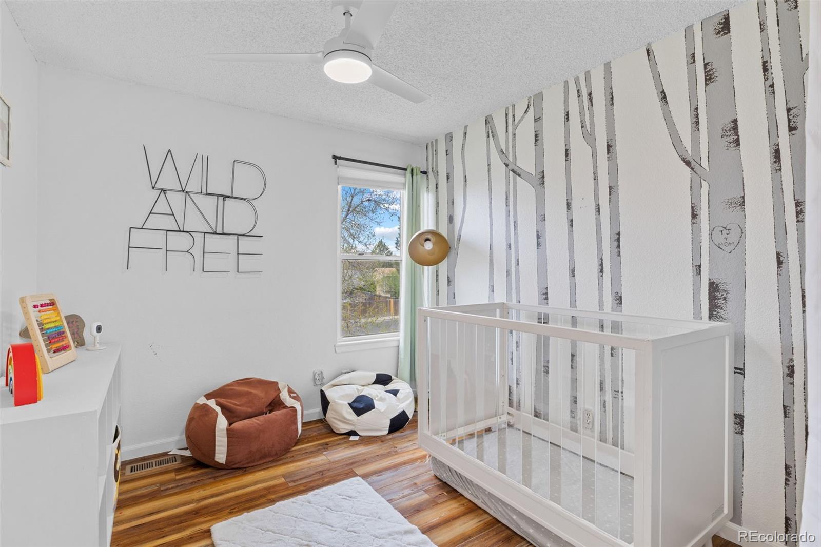 8674 Carr Loop Arvada, CO 80005 - Photo 23 of 43 a room with lots of white furniture and a baby crib