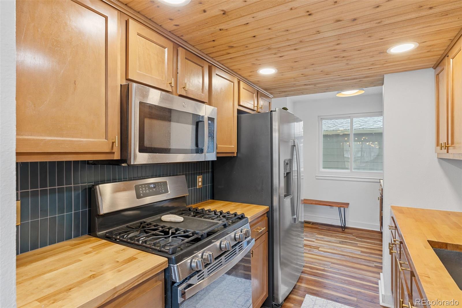 8674 Carr Loop Arvada, CO 80005 - Photo 6 of 43 a kitchen with stainless steel appliances granite countertop a stove a sink and a microwave
