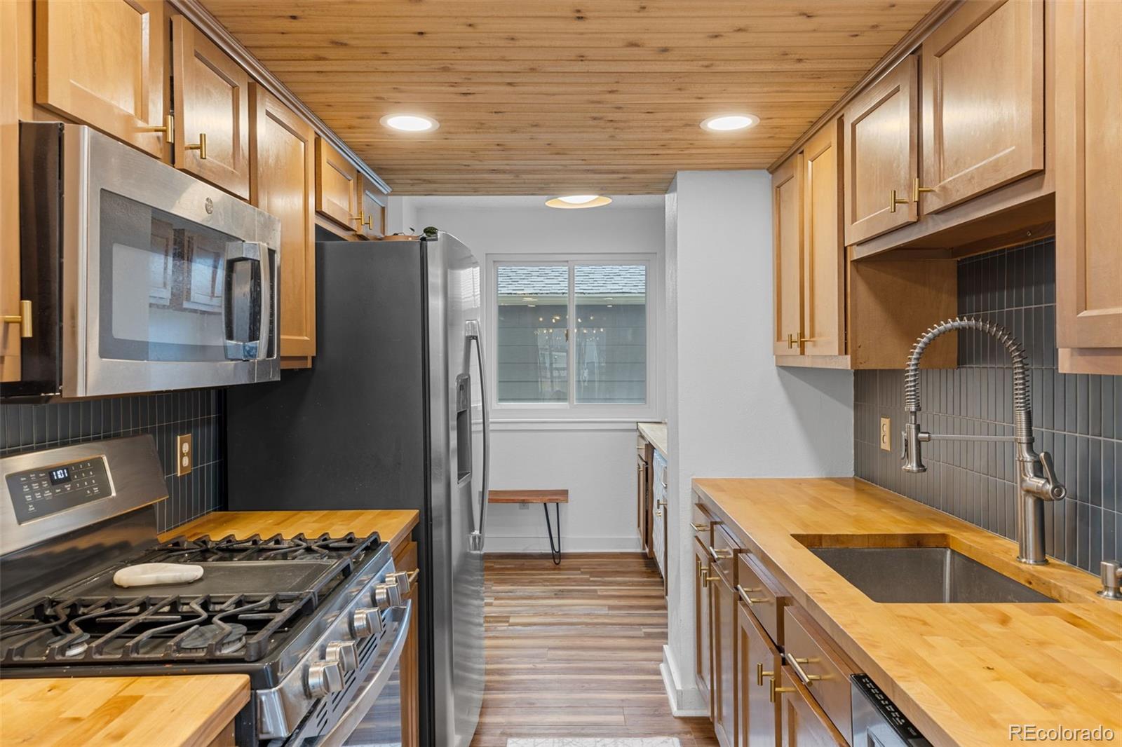 8674 Carr Loop Arvada, CO 80005 - Photo 7 of 43 a kitchen with stainless steel appliances granite countertop a stove a sink and a refrigerator