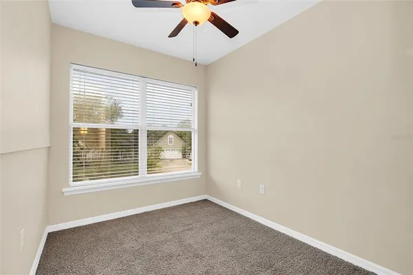 an empty room with a window and a ceiling fan