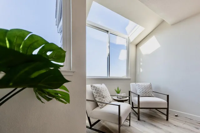 a view of a hallway with furniture and a potted plant