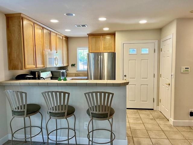 a kitchen with a table chairs refrigerator and cabinets