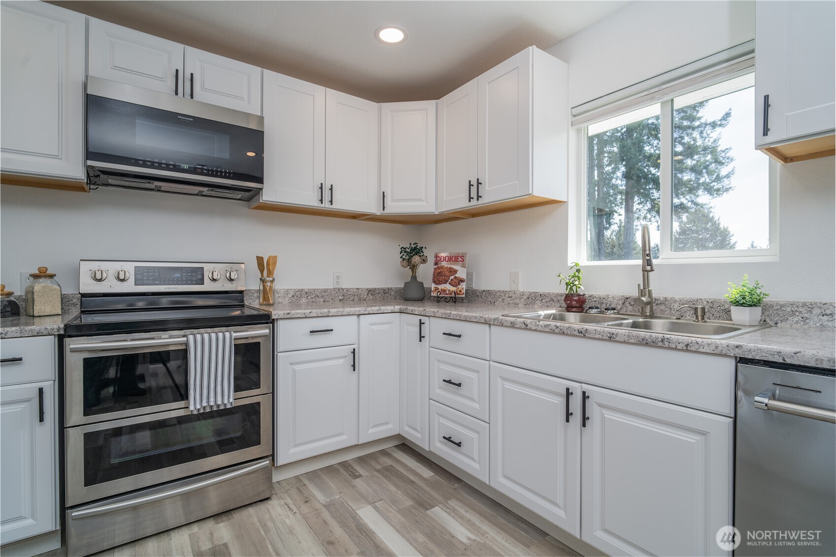 10327 185th Avenue Southwest Rochester, WA 98579 - Photo 9 of 27 a kitchen with granite countertop white cabinets stainless steel appliances and a window