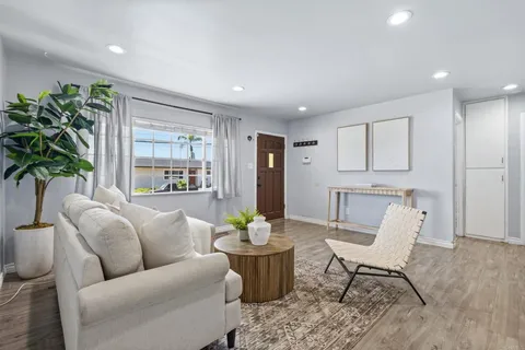a living room with furniture and a potted plant