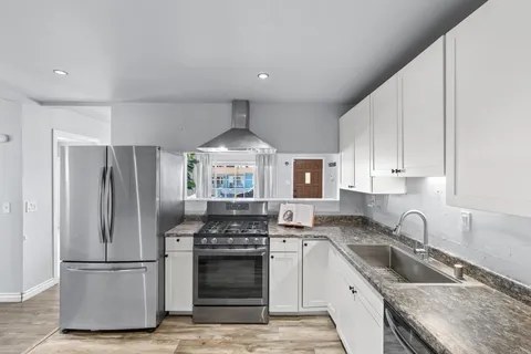 a kitchen with a refrigerator stove and sink
