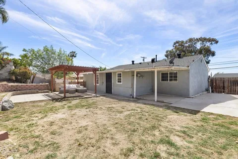 a view of a house with backyard and a tree