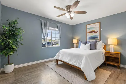 a bedroom with a bed lamp and a potted plant
