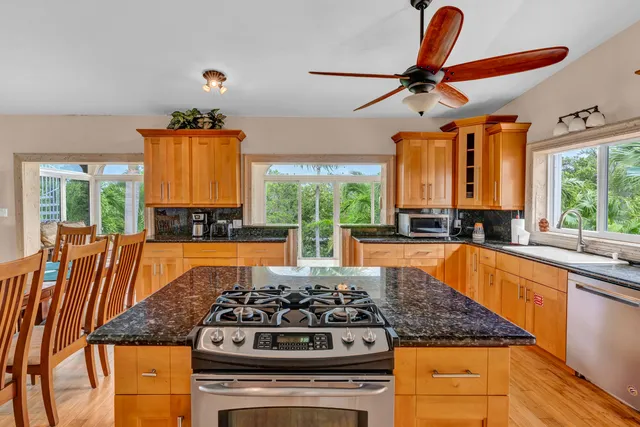 a kitchen with stainless steel appliances granite countertop a stove a sink and a refrigerator
