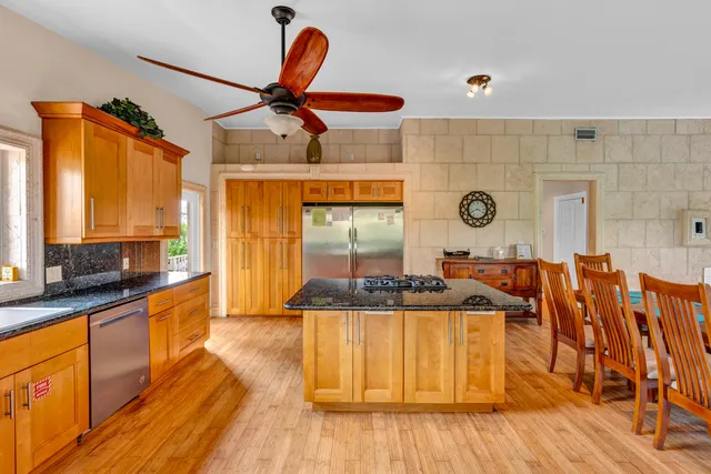 a kitchen with stainless steel appliances wooden floor dining table and chairs