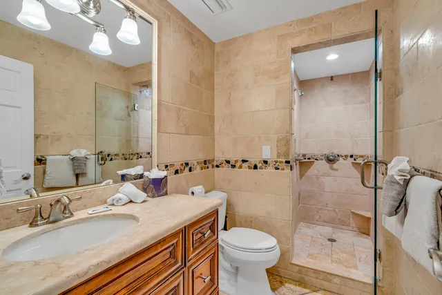 a bathroom with a sink a toilet and shower