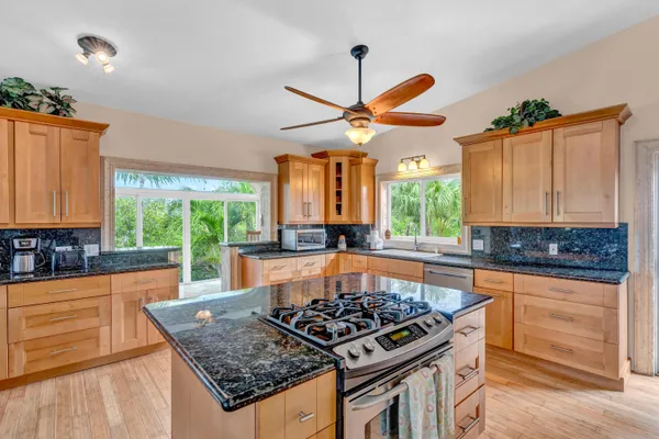 a kitchen with a stove a sink and a wooden cabinets