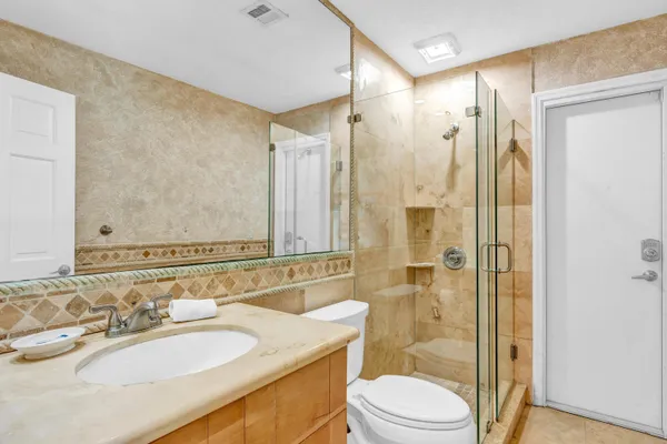a bathroom with a sink a toilet and shower
