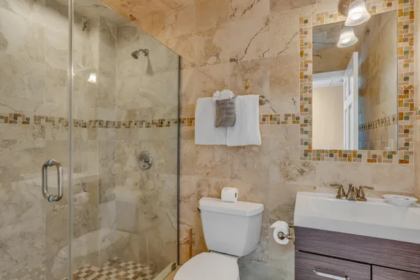 a bathroom with a sink toilet a mirror and shower