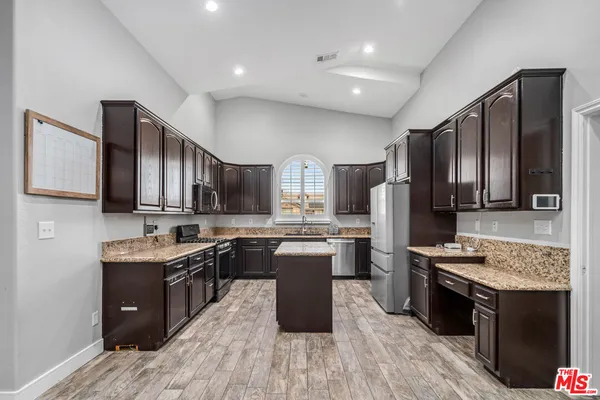 a kitchen with a sink stove cabinets and refrigerator