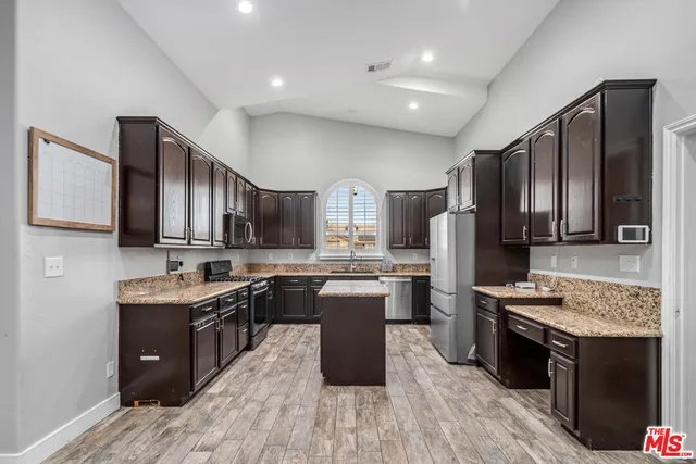 a kitchen with a sink stove cabinets and refrigerator