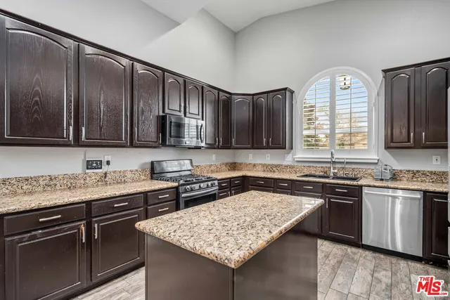 a kitchen with stainless steel appliances granite countertop a sink stove and cabinets